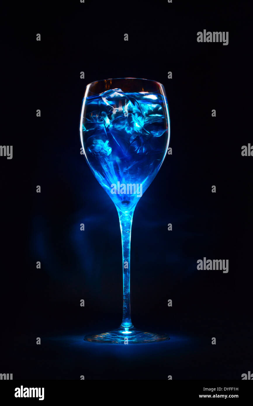 Erstaunlich blauen Cocktail mit Eiswürfeln in hohen Glas. Blue Curaçao Likör. Magische Lichter und Schatten. Stockfoto