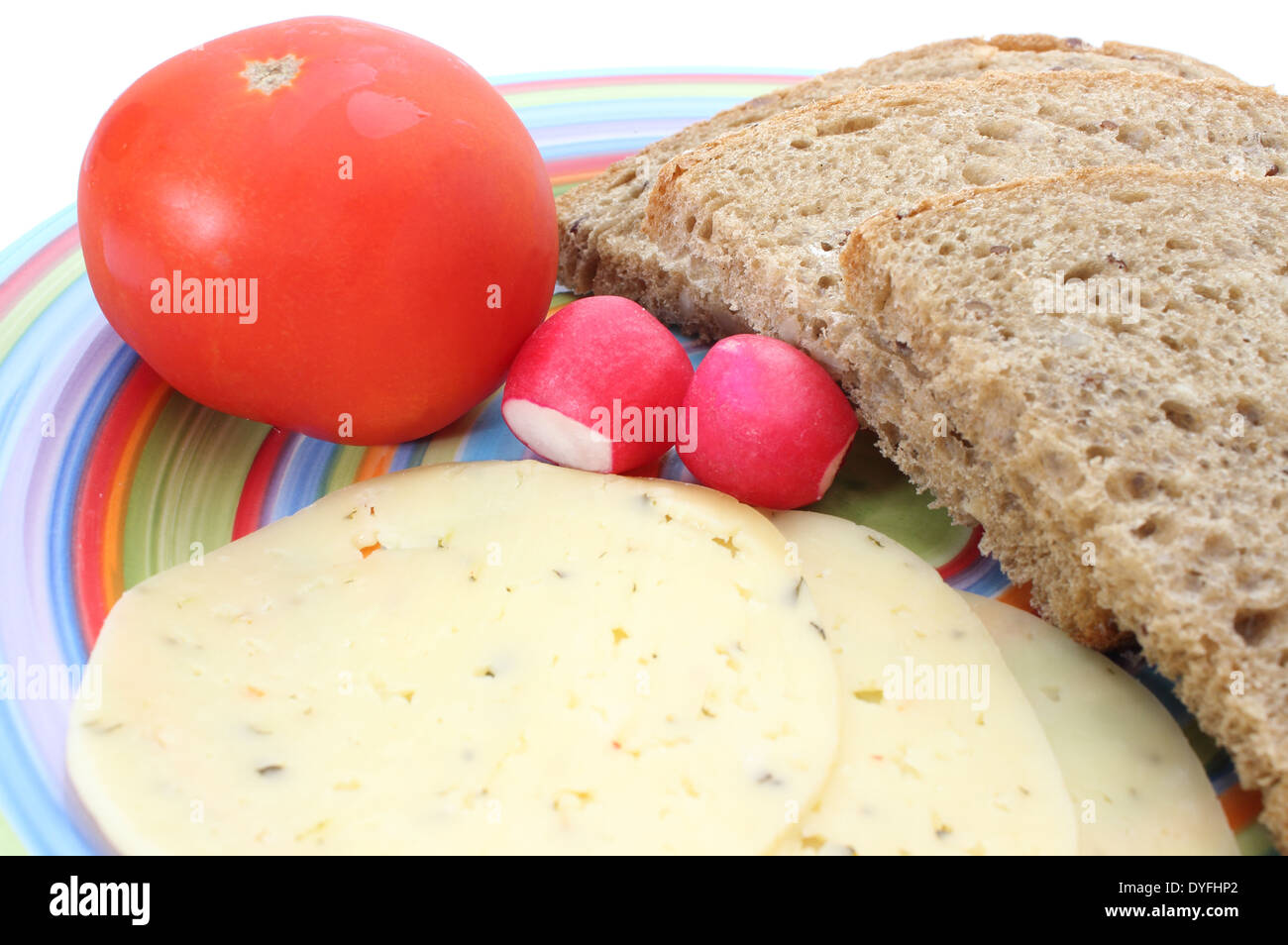 Scheiben von Roggenbrot, Tomaten, Käse, Rettich auf einem farbigen Teller Stockfoto