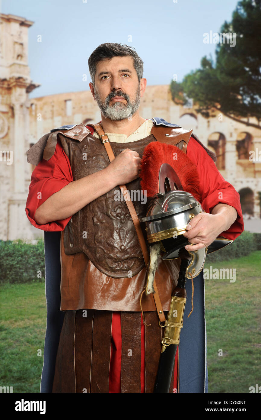 Römische Soldaten salutieren mit Faust auf Brust über Kolosseum im Hintergrund Stockfoto