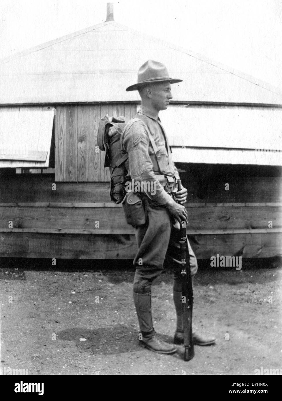 Z. B. Leonhardt besondere Sammlung Foto Seitenprofil der Mann mit Hut, Rucksack und Gewehr vor einen Rundbau aus Holz Stockfoto