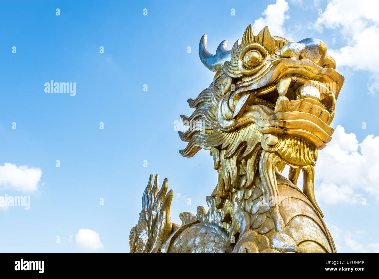 Goldener Stein Drachenstatue in Vietnam mit Gesicht Nahaufnahme auf blauen Himmelshintergrund. Links anzeigen. Symbol der vietnamesischen Mythologie. Stockfoto