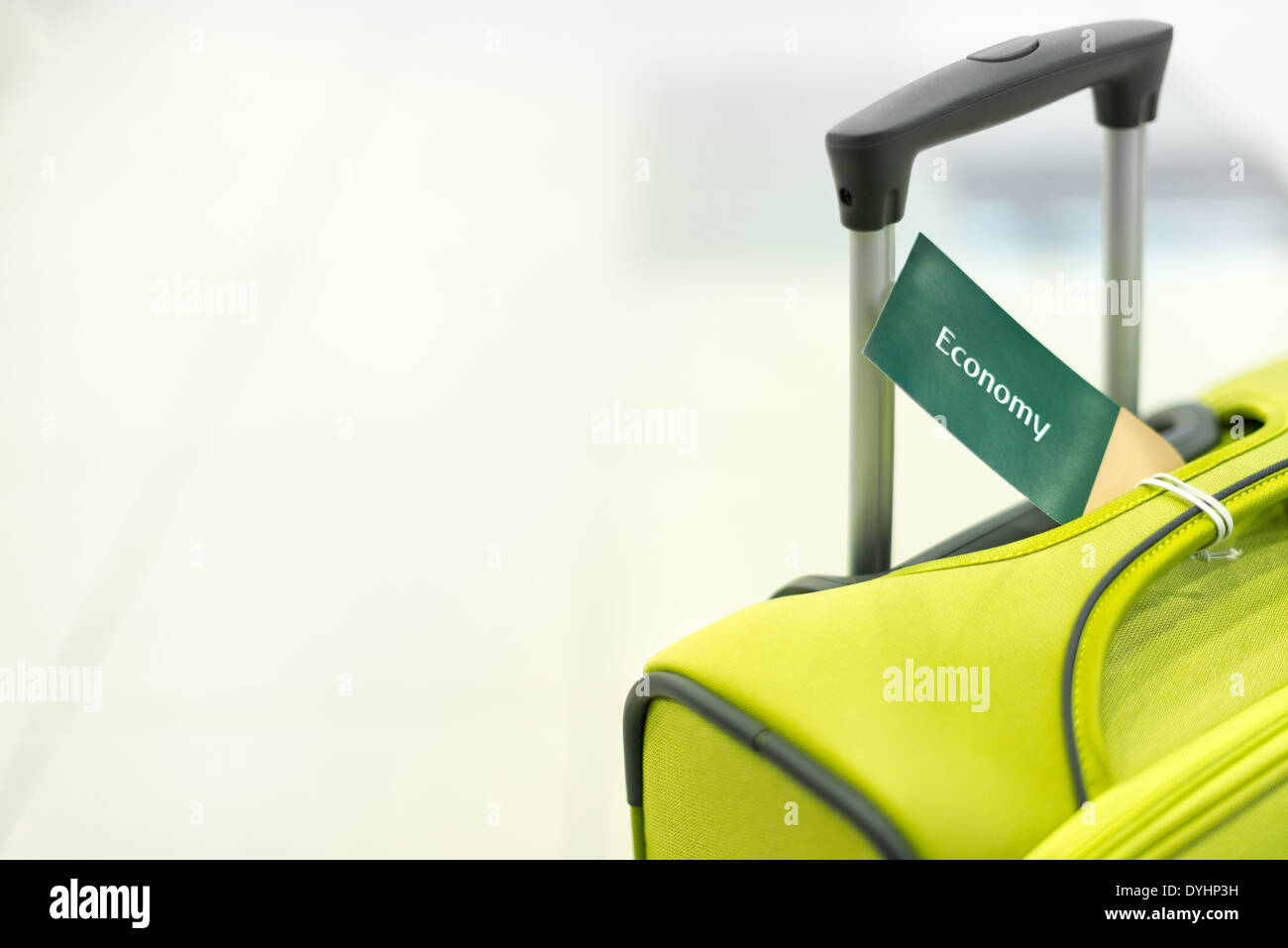 Hell-Koffer mit Griff und Label Wirtschaft. Gepäck am Flughafen. Moderne und elegante Tasche für die Reise. Objekt auf weißem Hintergrund Stockfoto