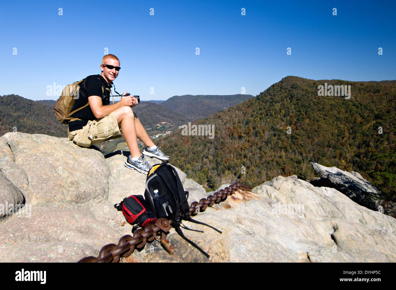Touristen mit Kamera Sitting on Top of verkettete Rock im Pine Mountain State Park im Bell County Kentucky Stockfoto