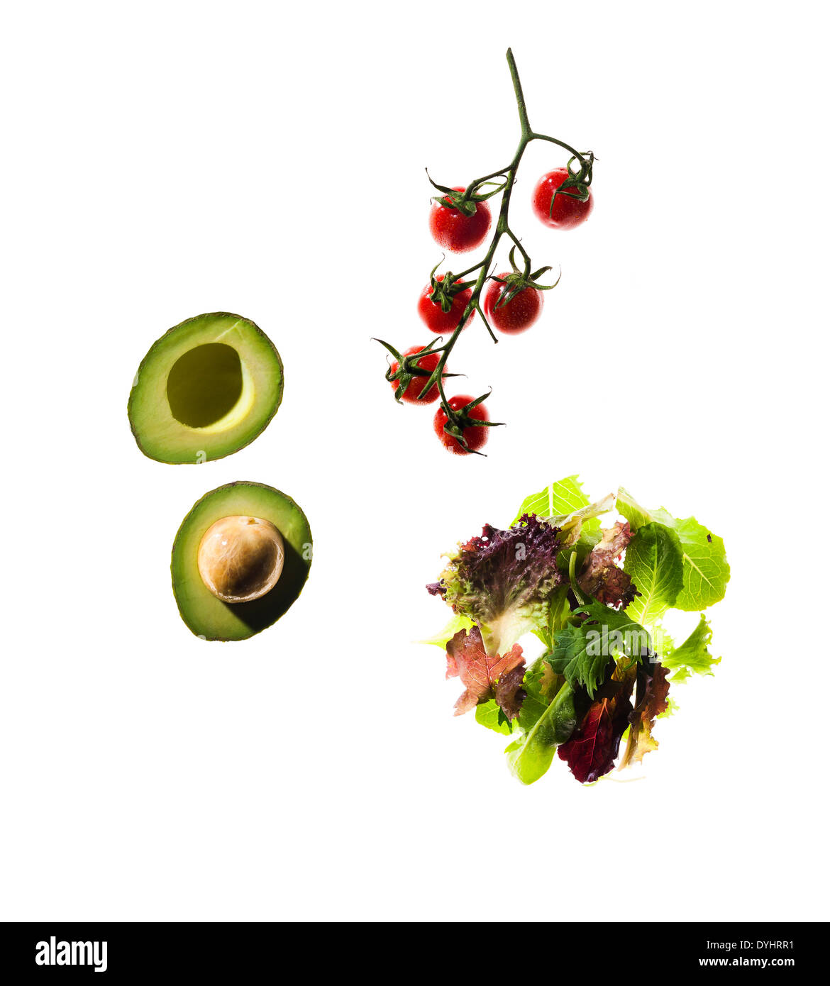 Cherry-Tomaten, Salat, Blätter und geschnittene Avocado auf weißem Hintergrund Stockfoto