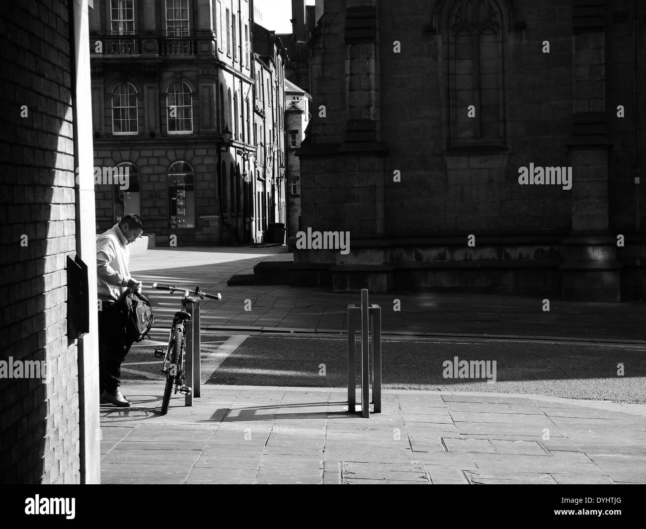Mann Parken Fahrrad in Stadt Street, Newcastle Upon Tyne, England, UK Stockfoto
