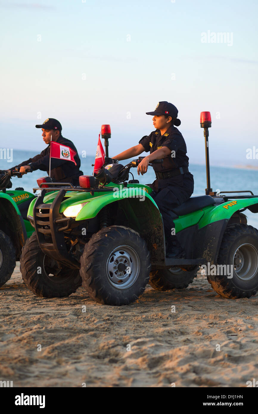 Nicht identifizierte Polizistin und Polizist auf Honda Geländewagen am Sandstrand in Mancora, Peru Stockfoto