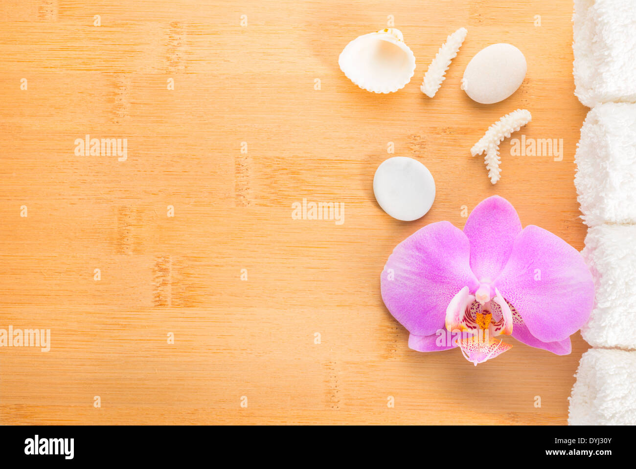Filiale lila Orchidee, Muscheln und weiße Handtücher auf Bambus Holz Hintergrund Stockfoto