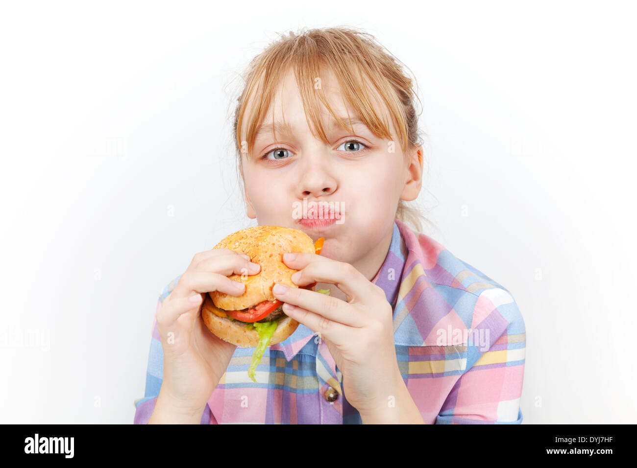 Kleines blondes Mädchen isst Burger auf weißem Hintergrund Stockfoto