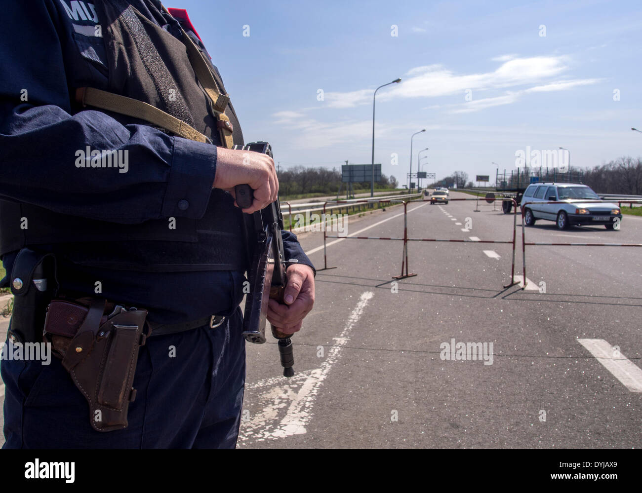 Lugansk, Ukraine. 19. April 2014. Polliceman auf Verordnung Verkehrsknotenpunkt---In Lugansk angespannt. Stadt umgeben Verkehrsregelung Punkt. Polizei, bewaffnete Kalaschnikow überprüfen Sie sorgfältig jeden PKW und LKW. Fahrer und Beifahrer werden zu diesem Verständnis behandelt. Bildnachweis: Igor Golovnov/Alamy Live-Nachrichten Stockfoto