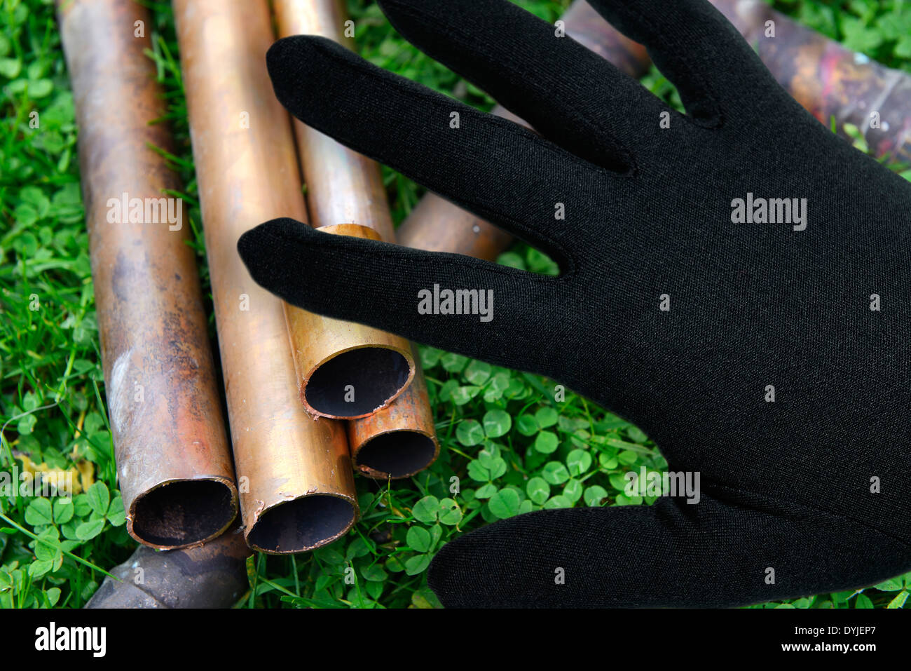 Schwarze Hand Über Kupferrohren, Symbolfoto Kupferdiebstahl Stockfoto