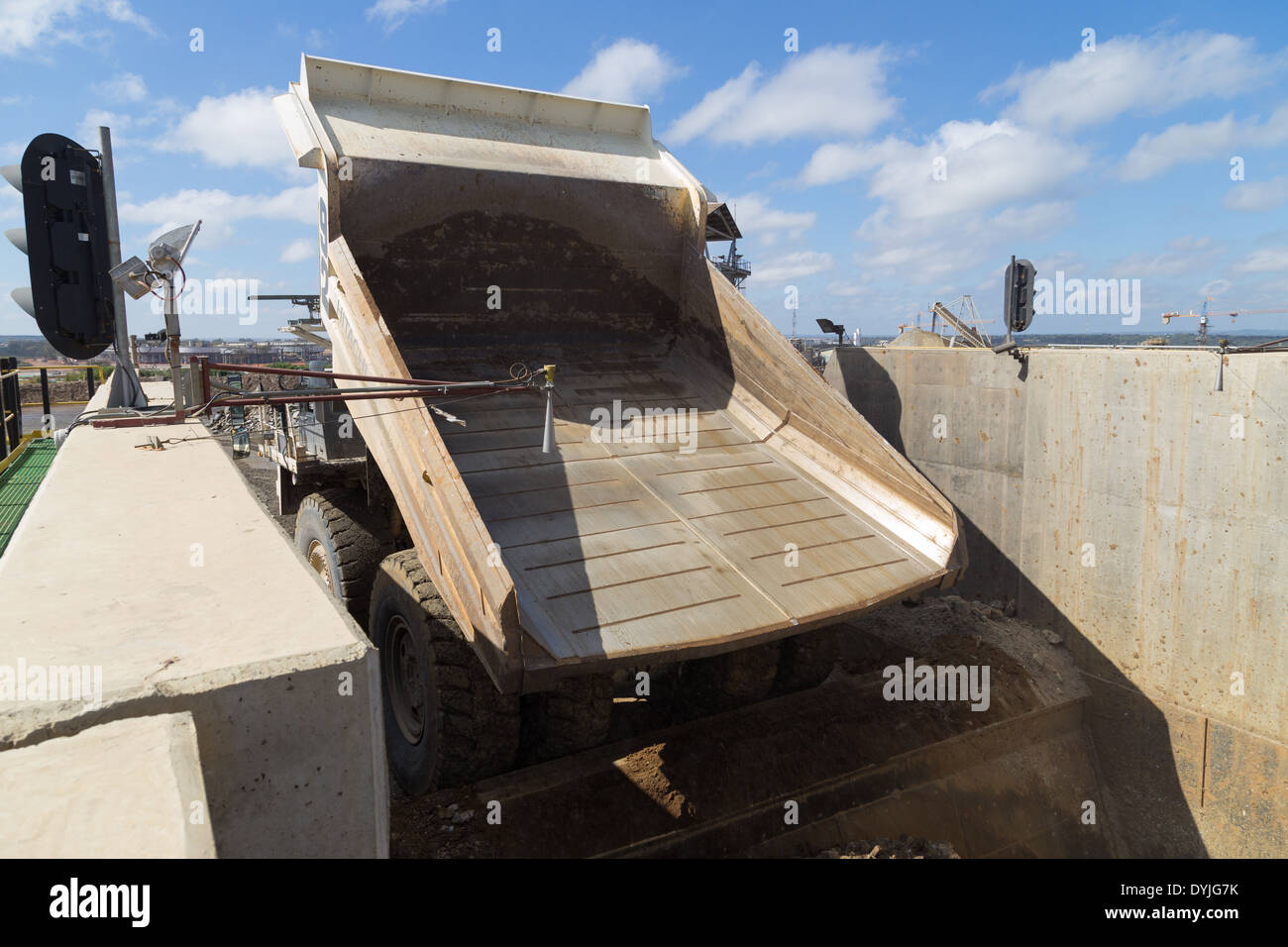 Eine massive Hitatchi Diesel / Elektro-Hybrid-Muldenkippers dumping Rock in einem Brecher in einem offenen werfen mir. Stockfoto