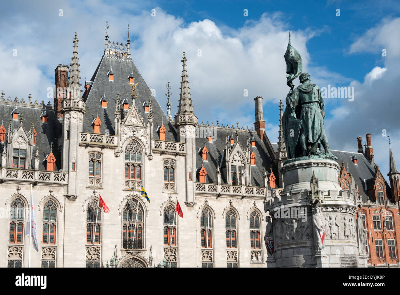 Jan Breydel und Pieter de Coninck Monument Brügge Belgien / BRÜGGE, Belgien — das Jan Breydel und Pieter de Coninck Monument steht vor dem neogotischen Provinzgericht im zentralen Markt der Stadt. Die Bronzefiguren zeigen einen lokalen Metzger und Weber, der einen flämischen Aufstand gegen die französischen Besatzungsmächte organisierte. Das Paar hielt ihr Banner hoch und führte eine Infanterie von einfachen Männern an, die französische Ritter in der Schlacht an den Goldenen Sporen am 11. Juli 1302 besiegten. Das Denkmal wurde 1887 enthüllt, von Paul de Vigne gestaltet und architektonisch von Louis Delacenserie, dem Stadtarchiv von Brügge, entworfen Stockfoto