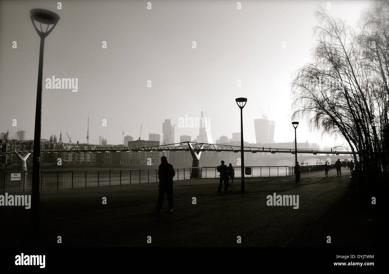 Frühmorgens am Südufer der London entlang der Themse - Blick über die City of London und die Millennium Bridge Stockfoto