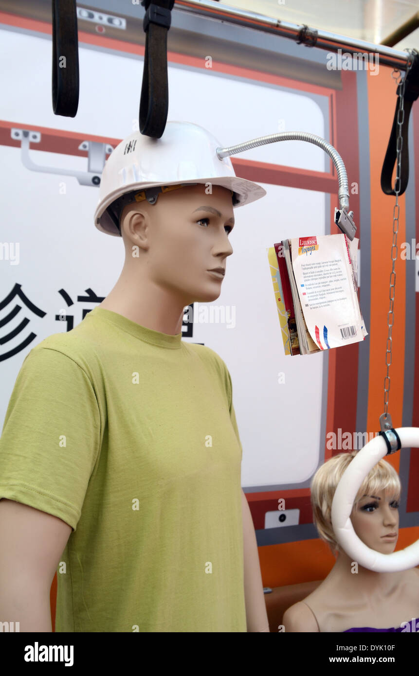 Männlichen Zug Passagier oder Dummy schwer Helm mit Buchstütze in Zug. Nutzlose japanische Gadget oder Chindogu. Stockfoto