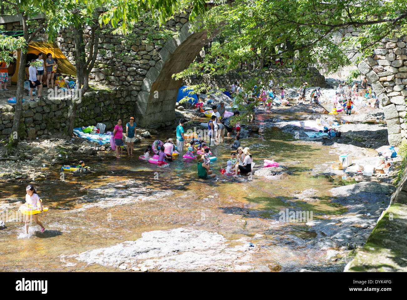 Leute genießen ein Bad in einem kleinen Fluss im Sommer in Yeosu/Südkorea in der Nähe von Stockfoto