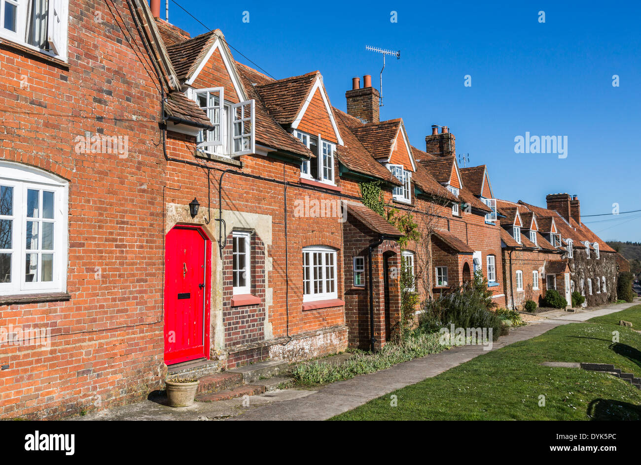 Leuchtend rote Tür in der Zeile der Hütten im Dorf Great Bedwyn, Wiltshire, UK, viele jetzt zweite Häuser oder Hütten Wochenende Stockfoto