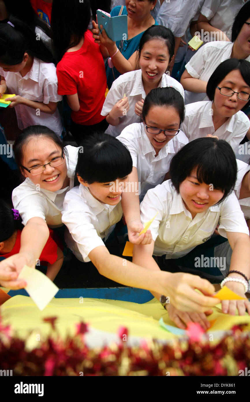 Haikou. 21. April 2014. Studenten kleben ihre Wünsche auf eine Wand während der Coming-of-Age-Zeremonie in Hainan Middle School in Haikou, der Hauptstadt der Provinz Süd-China Hainan, 20. April 2014. Mehr als 1.000 Studenten im Alter von 18, die gesetzliche Volljährigkeit, beteiligte sich an der "Coming of Age"-Zeremonie hier. © Xinhua/Alamy Live-Nachrichten Stockfoto