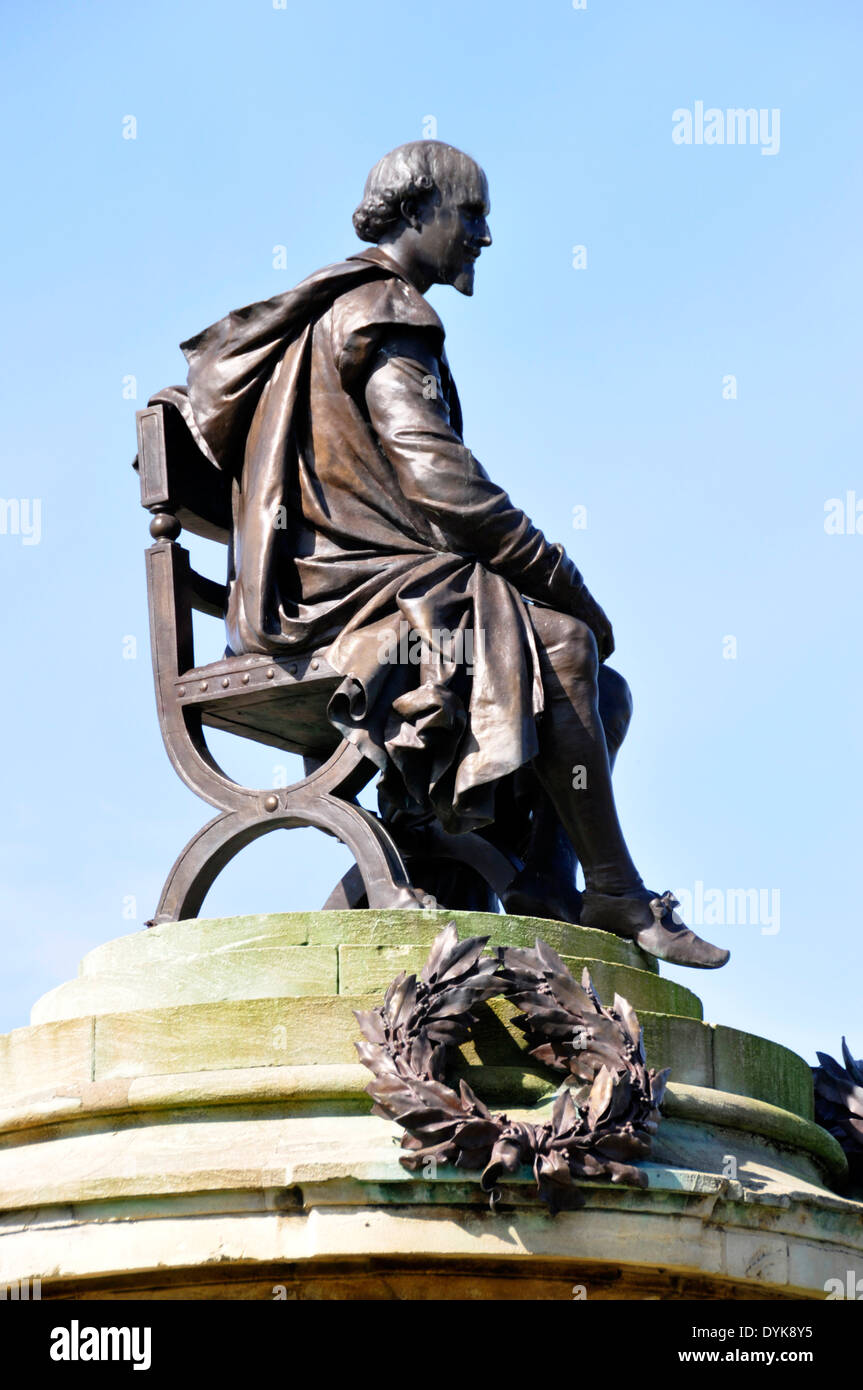 Stratford am Avon - Bancroft am Flussufer Gdns - erhöhte Statue von William Shakespeare sitzen - klassische Pose - blauer Himmel Hintergrund Stockfoto