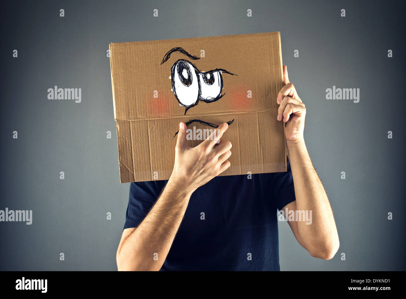 Mann mit Karton auf den Kopf mit ernsten Gesichtsausdruck zu denken. Stockfoto
