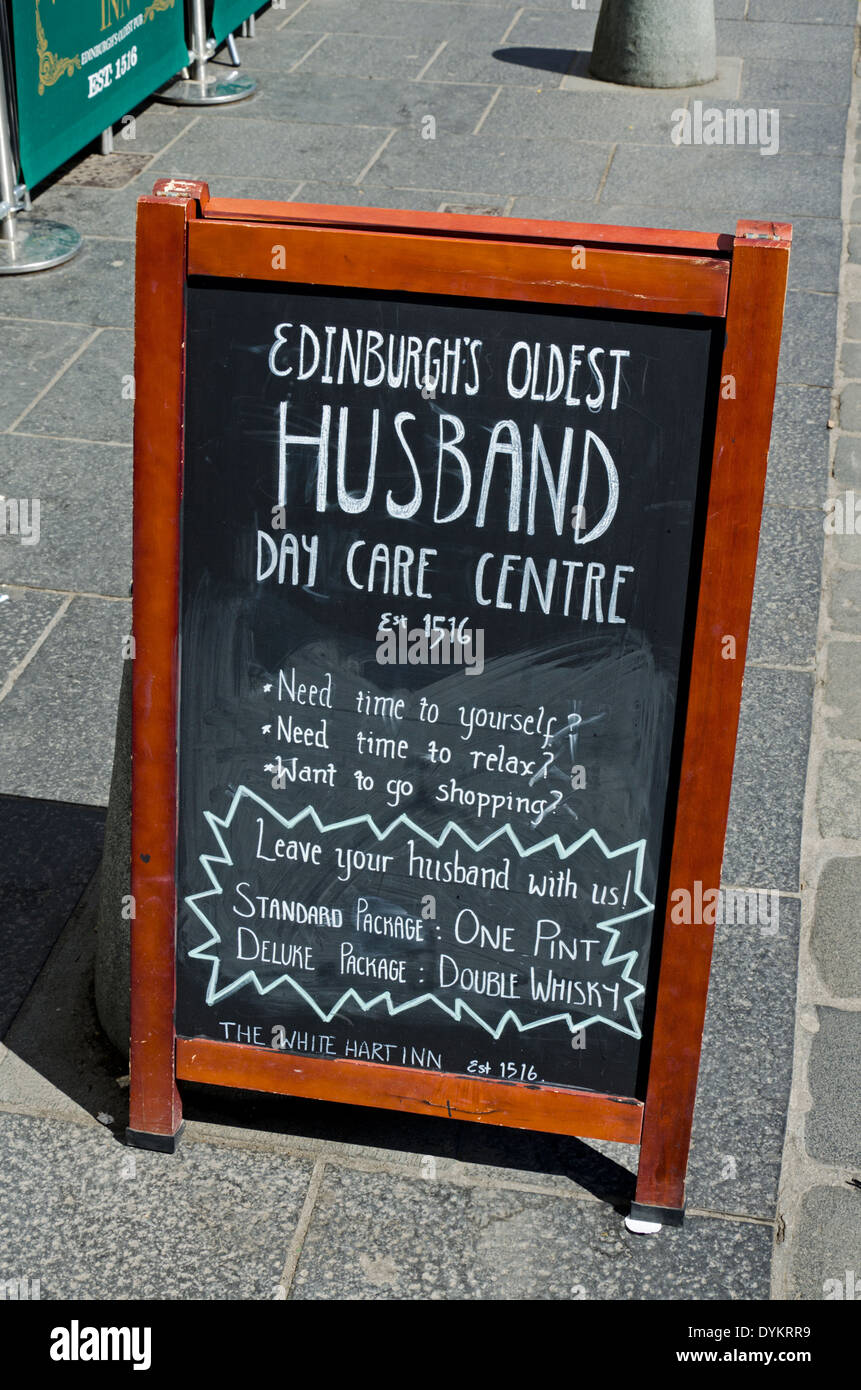 Eine komische Kneipe Zeichen Werbung "Edinburghs älteste Mann Day Care Centre" an der White Hart Inn in der Grassmarket. Stockfoto
