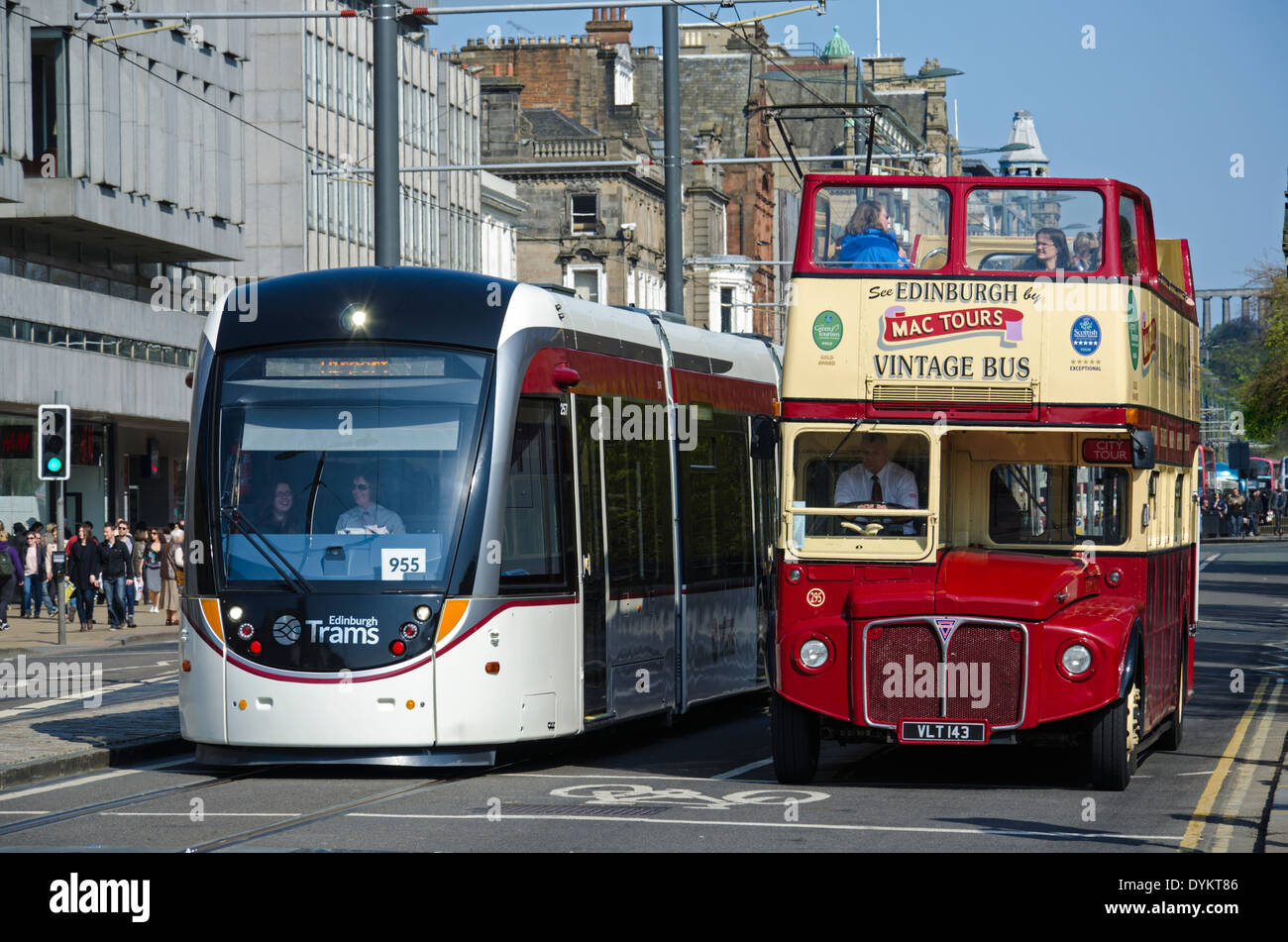 Kontrastierende Verkehrsträger, warten eine elektrische Straßenbahn und ein Vintage-Tour-Bus die Lichter an der Princes Street zu ändern. Stockfoto