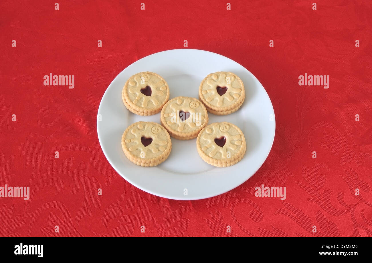 Teller mit Jammie Dodgers Kekse auf einer roten Tischdecke Stockfoto