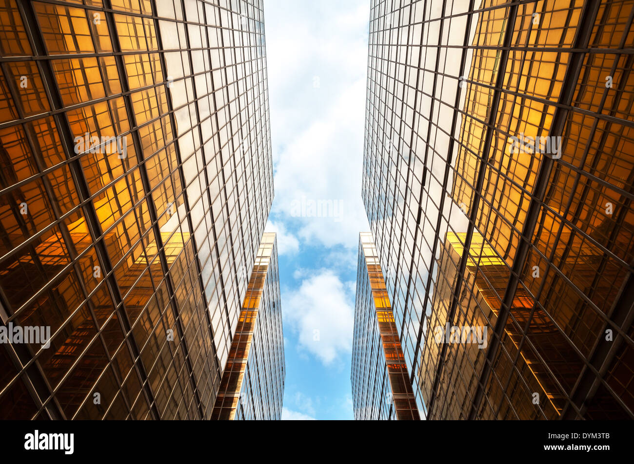 Nach oben Perspektive der symmetrischen zeitgenössische Wolkenkratzer mit blauem Himmel und weißen Wolken Stockfoto