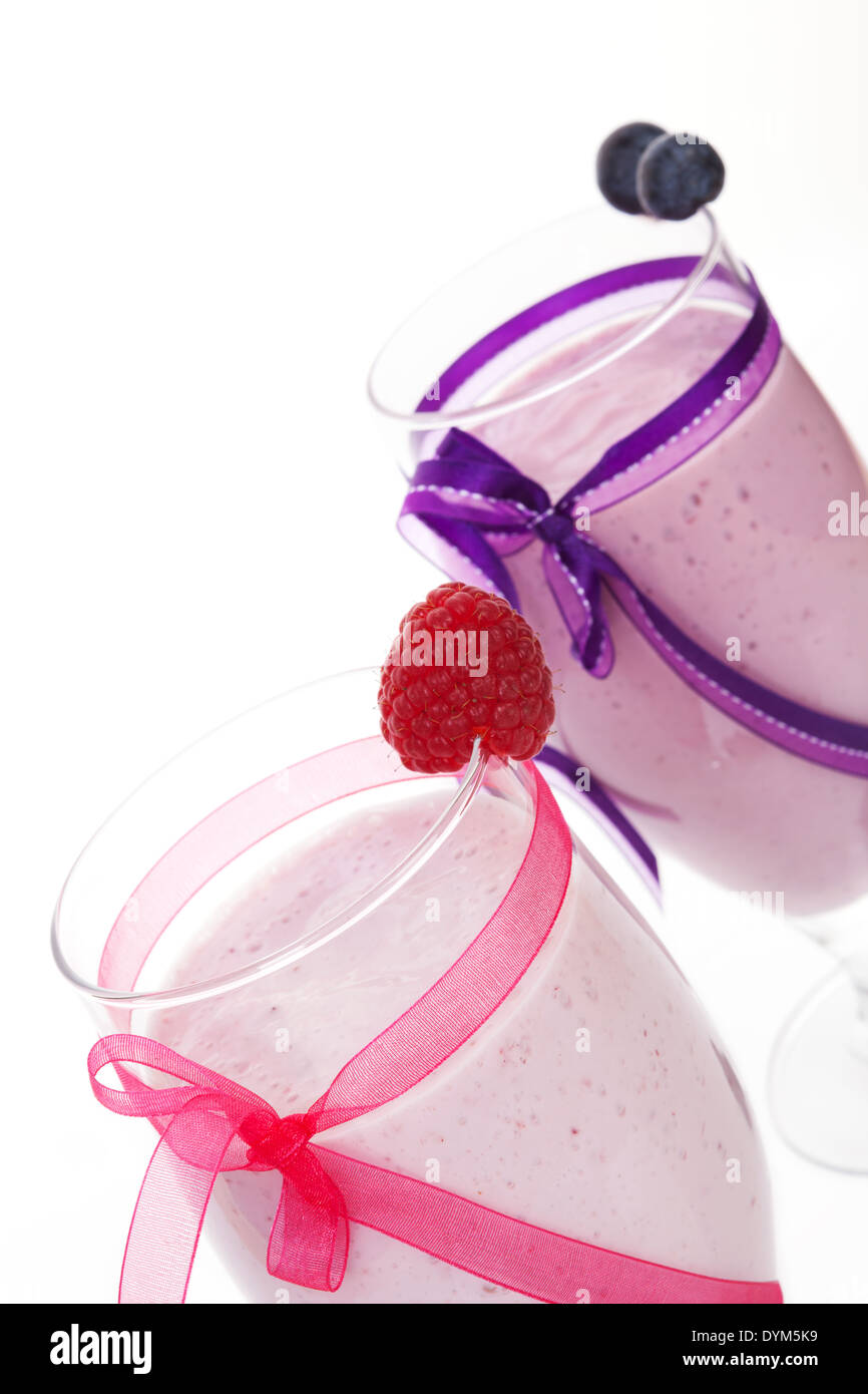 Himbeeren und Heidelbeeren Frucht Milchshakes mit Multifunktionsleiste isoliert auf weißem Hintergrund dekoriert. Luxuriöse gesunde Sommerdrink. Stockfoto