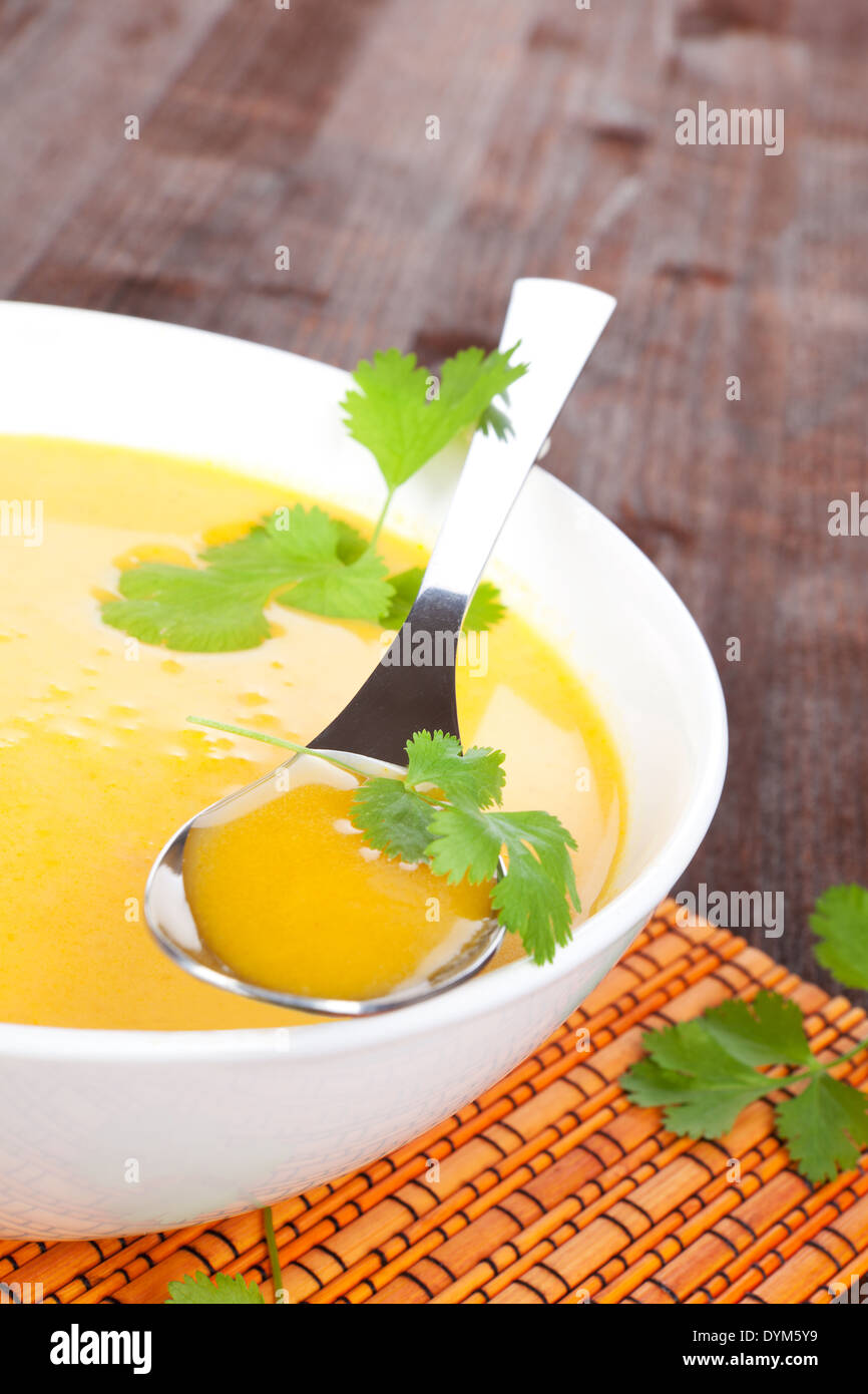 Leckere heiße Karottensuppe mit frischen Kräutern in weiße Schüssel. Gesunde Suppe, rustikalen Stil. Stockfoto