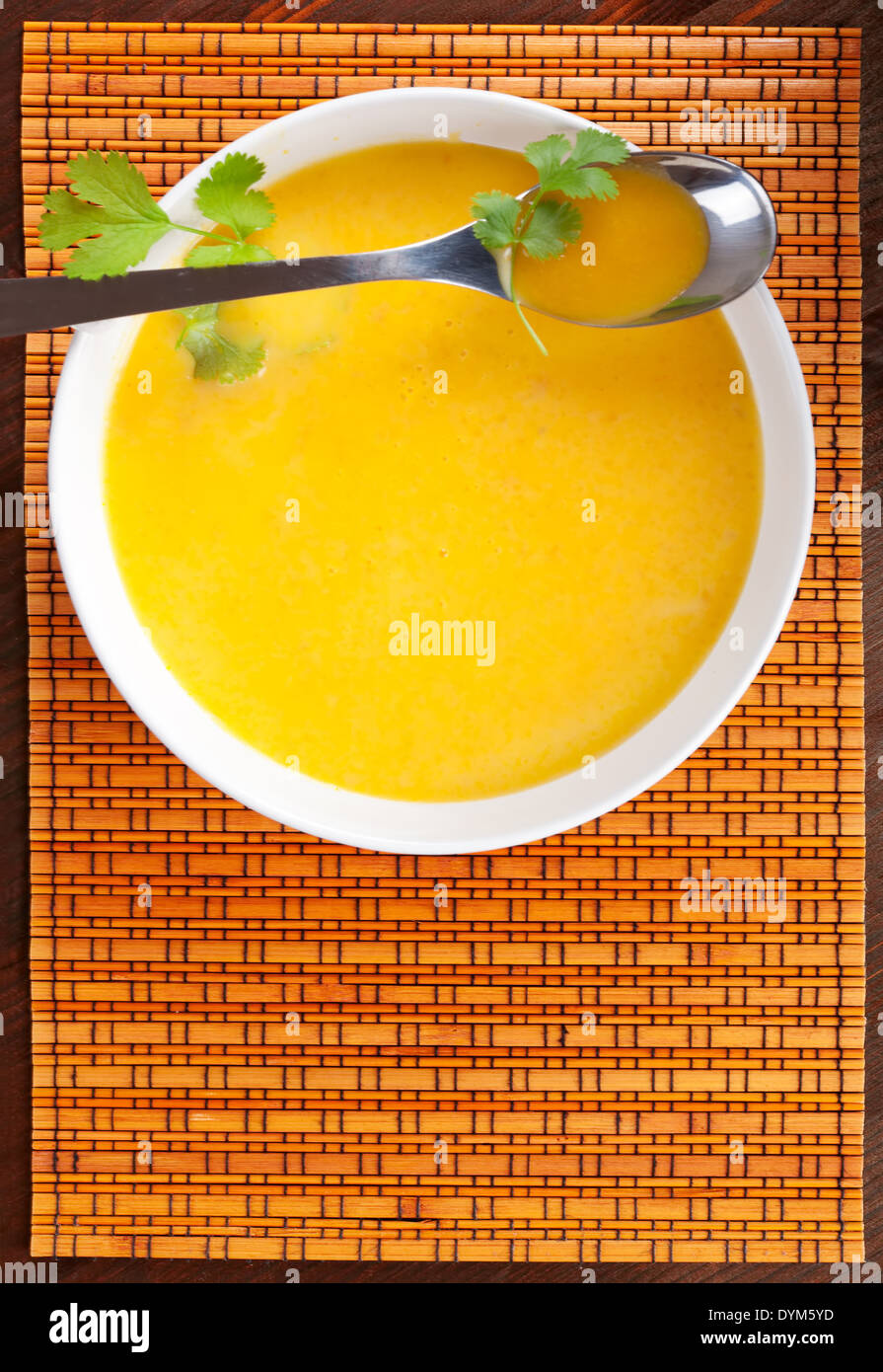Leckere Möhrensuppe in weiße Schüssel mit frischen Kräutern, Ansicht von oben. Kulinarischen Suppen. Stockfoto