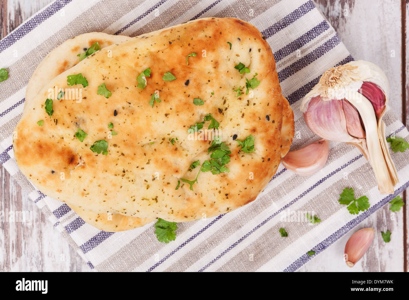 knoblauch-koriander-naan-stapeln-auf-k-chentuch-auf-wei-en-h-lzernen