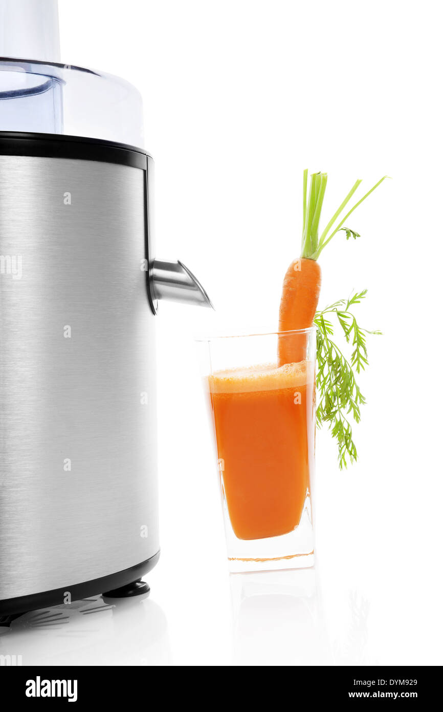 Frischer Karottensaft in Glas und Silber elektrische Saftpresse isoliert auf weißem Hintergrund mit Reflexion. Gesunder Lebensstil, minimal Stockfoto