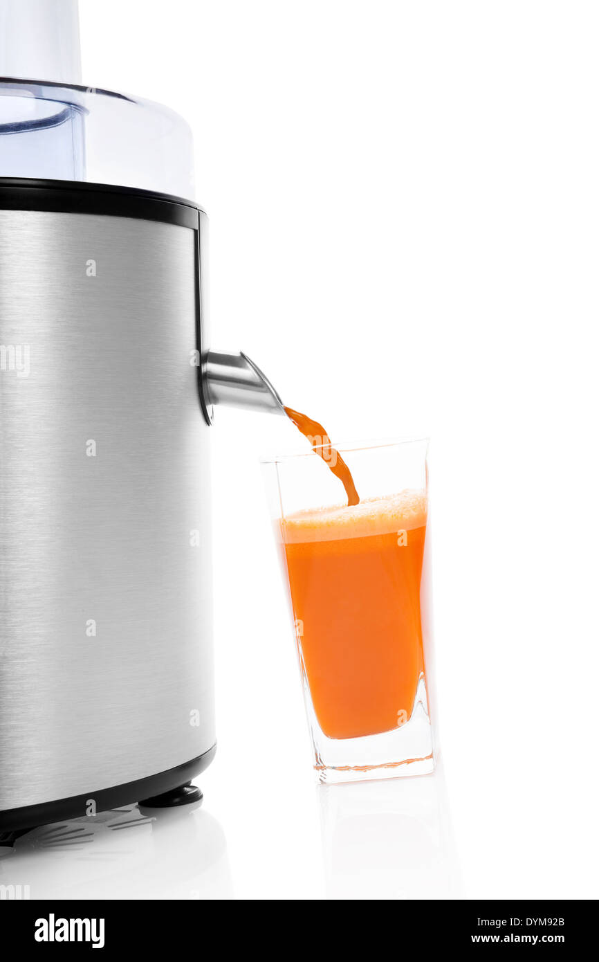Frischer Karottensaft in Glas und Silber elektrische Saftpresse isoliert auf weißem Hintergrund mit Reflexion. Gesunder Lebensstil, minimal Stockfoto