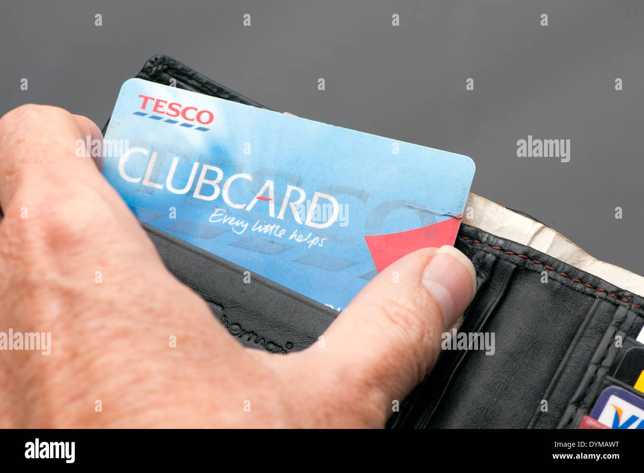 Hand unter einem Tesco Clubcard aus einer Brieftasche Stockfoto