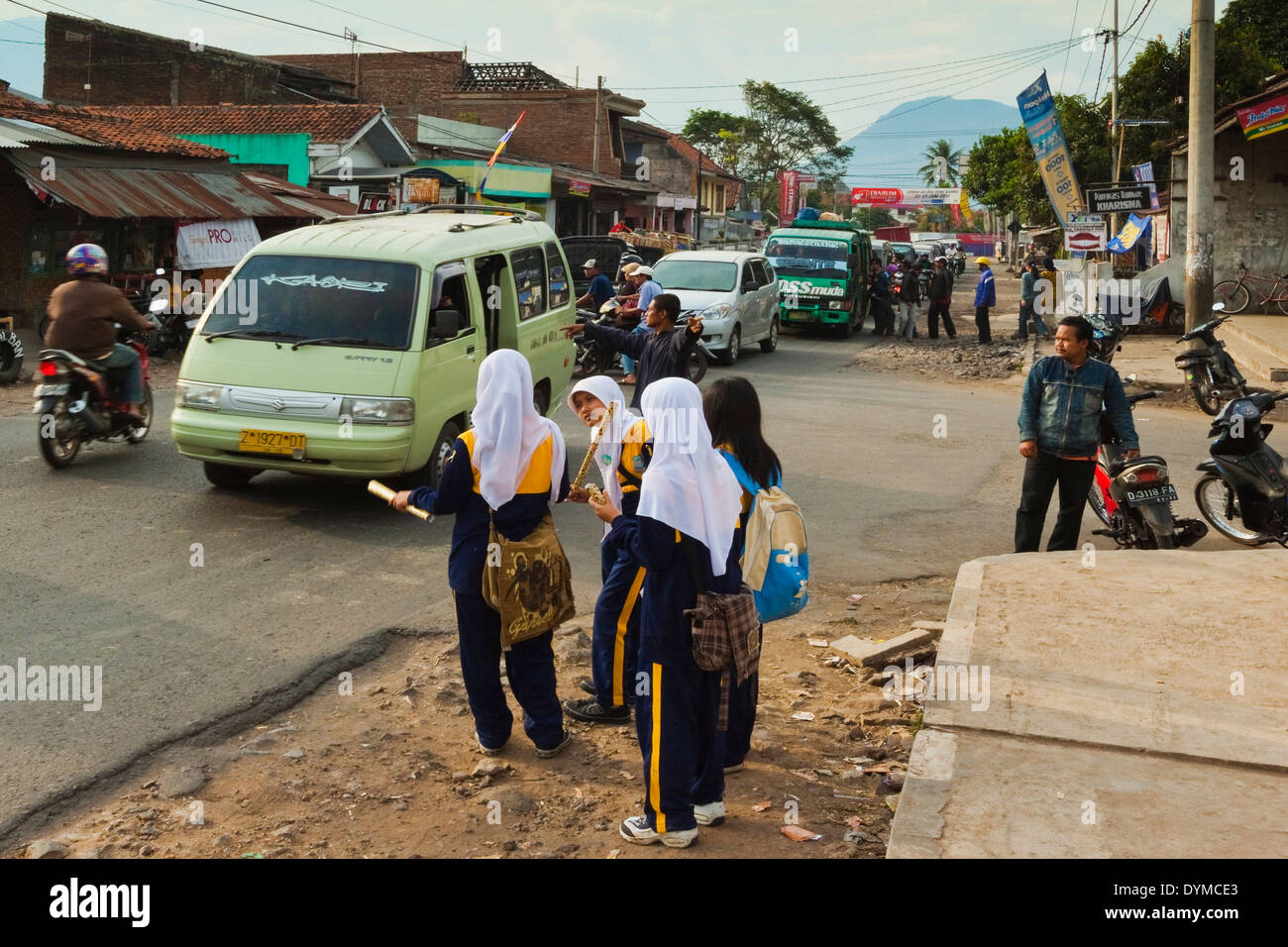 Schulmädchen tragen des Hijab warten auf der Straße für Bemo Kleinbus nach Hause in dieser ländlichen Gegend; Kecamatan Leles, Garut, Java, Indonesien Stockfoto