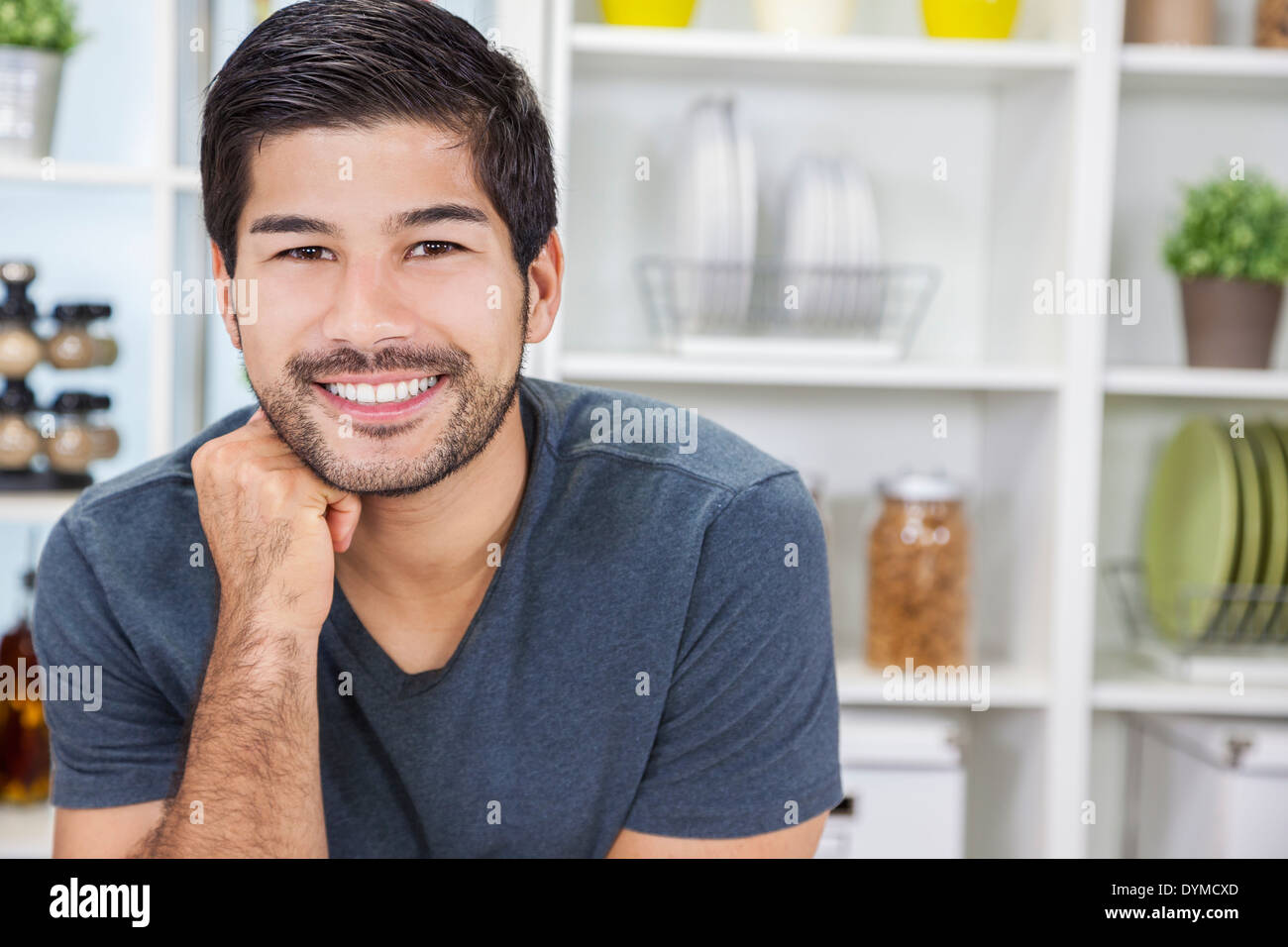 Porträt der schönen lächelnden jungen asiatischen Mann mit einem Bart in einer Küche zu Hause Stockfoto