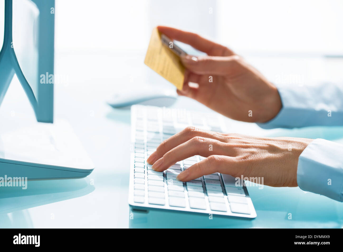 Frau Shopping im Internet mit Computer und Kreditkarte Stockfoto