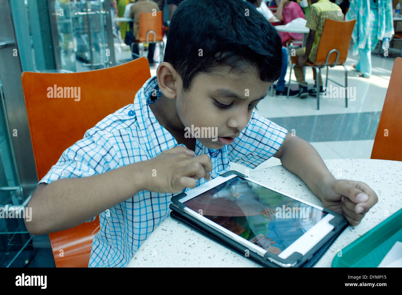 Indischen Jungen spielen auf dem ipad Stockfoto