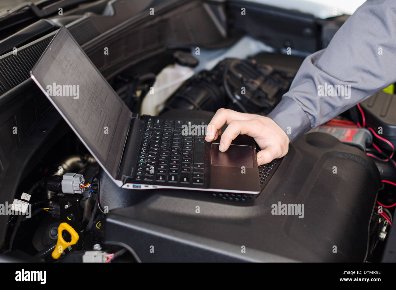 Mechaniker mit Laptop Diagnosen Auto in Werkstatt. Stockfoto