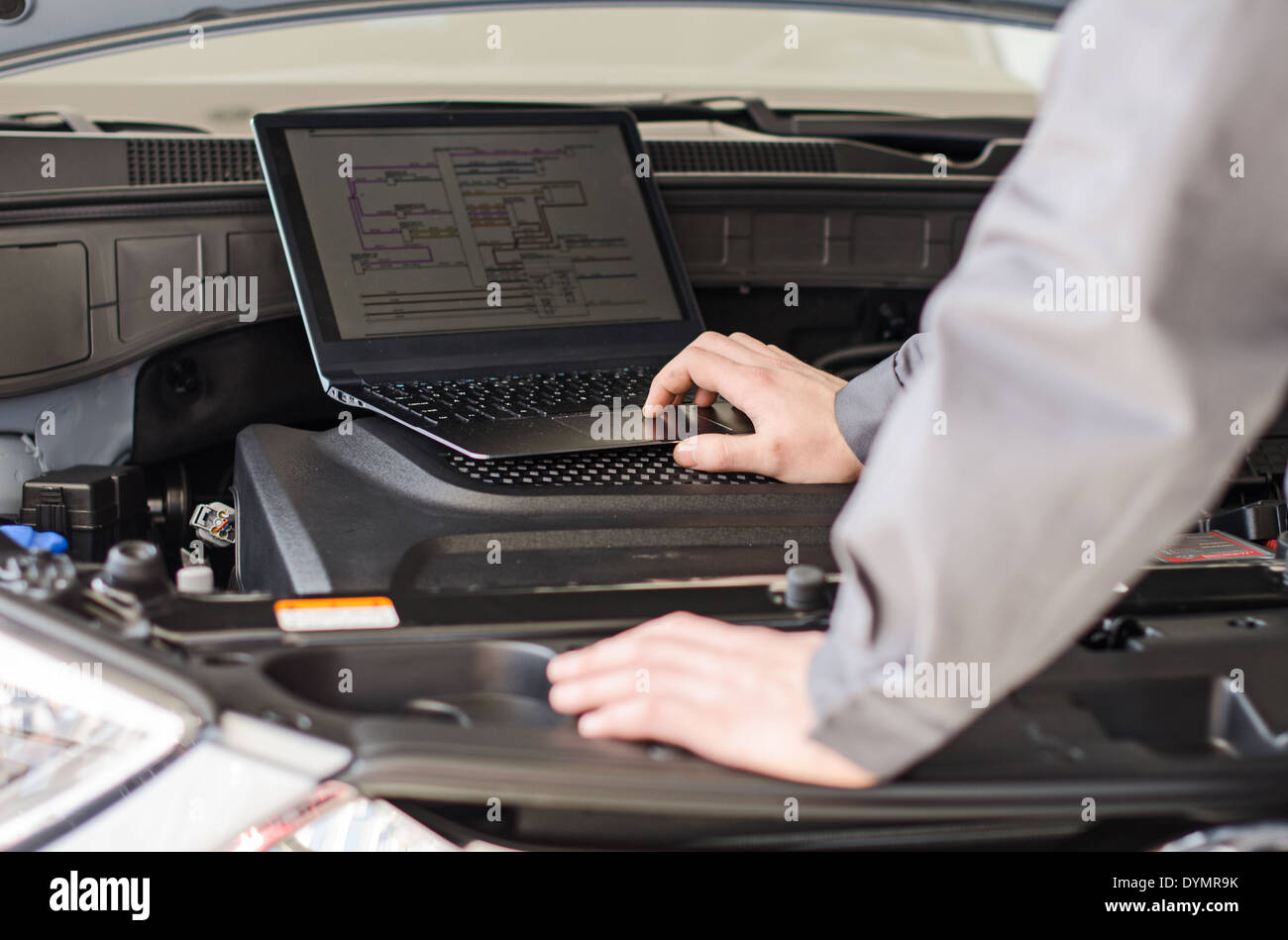 Mechaniker mit Laptop Diagnosen Auto in Werkstatt. Stockfoto