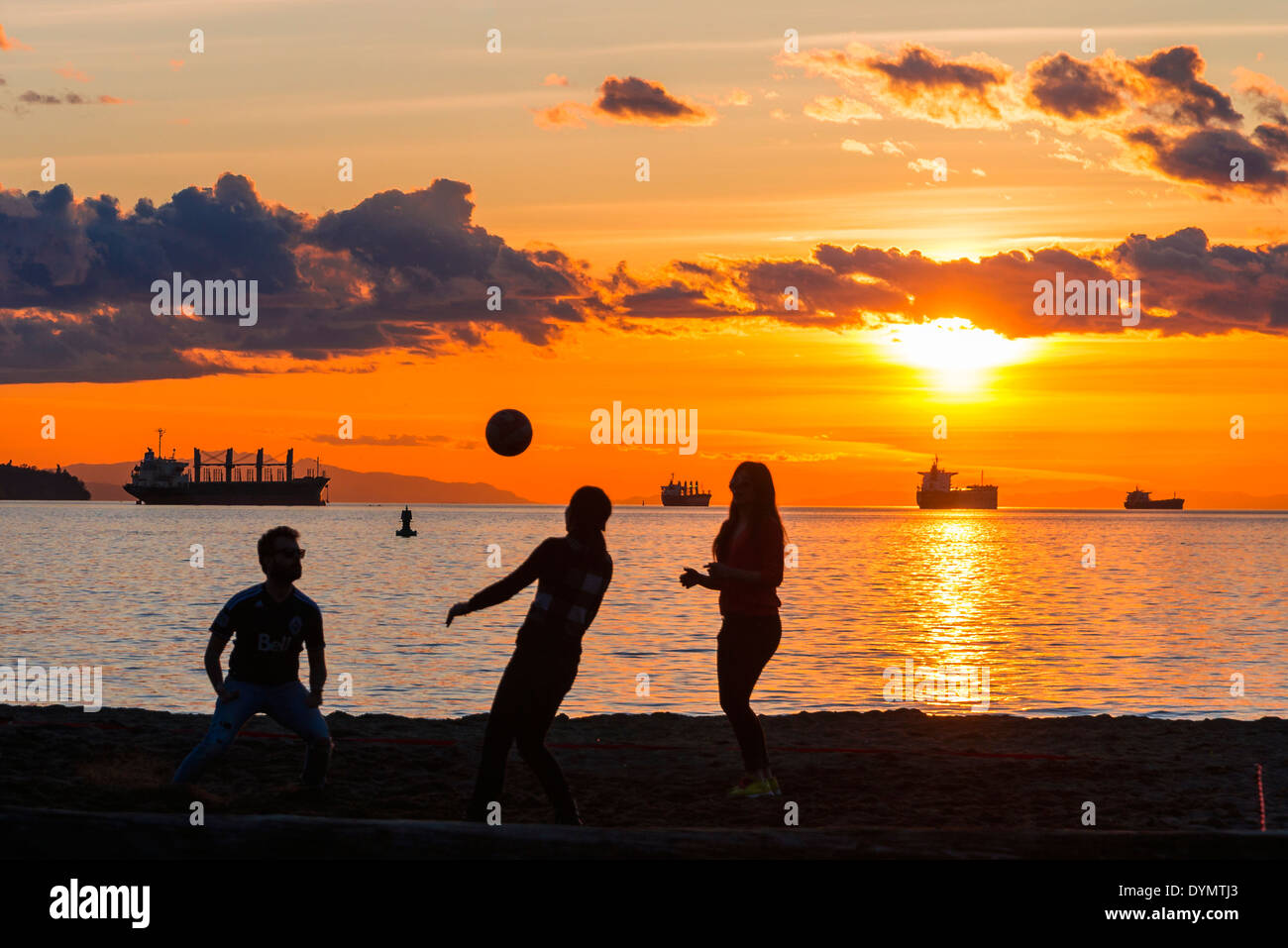 Eine Partie Beach-Volleyball bei Sonnenuntergang, Englisch Bay Beach, Vancouver, Britisch-Kolumbien, Kanada Stockfoto