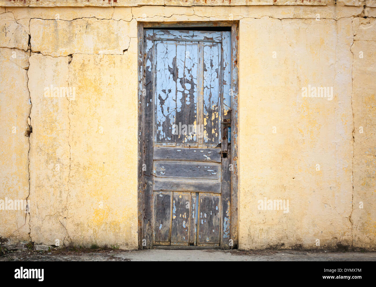 Alte Holztür in gelbe Wand. Hintergrundtextur Foto Stockfoto