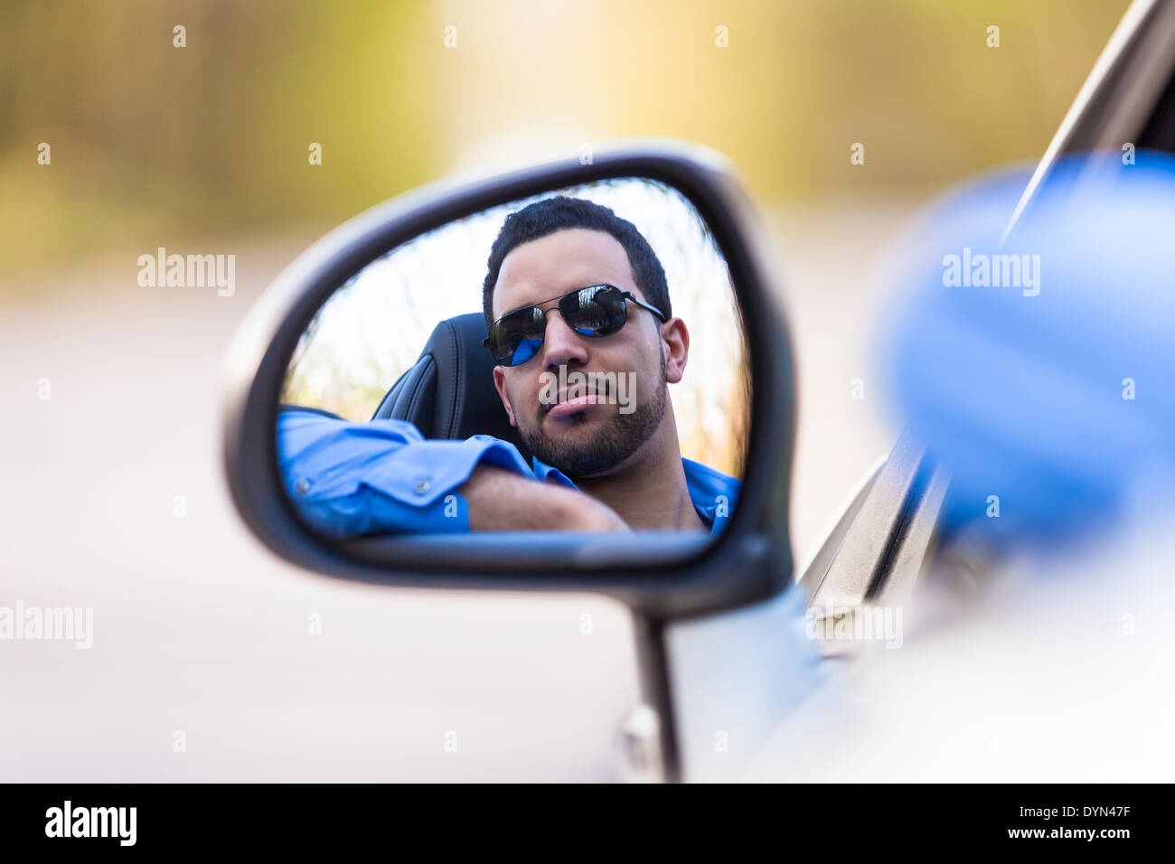 Junge schwarze lateinamerikanischen Fahrer mit seinem neuen Auto Stockfoto