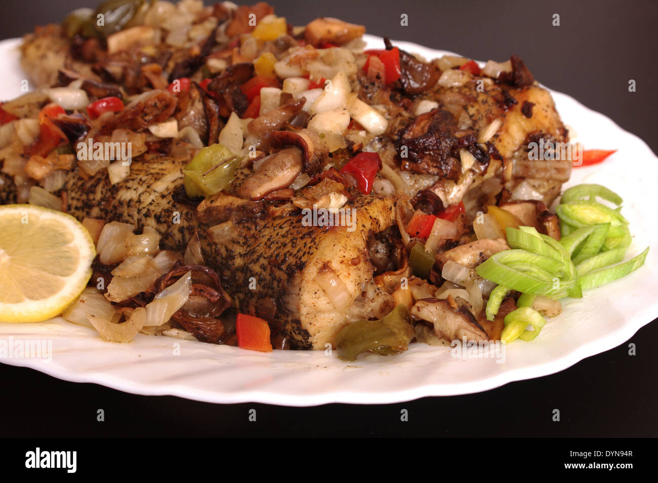 gebackener Fisch mit Gemüse auf Platte Stockfoto