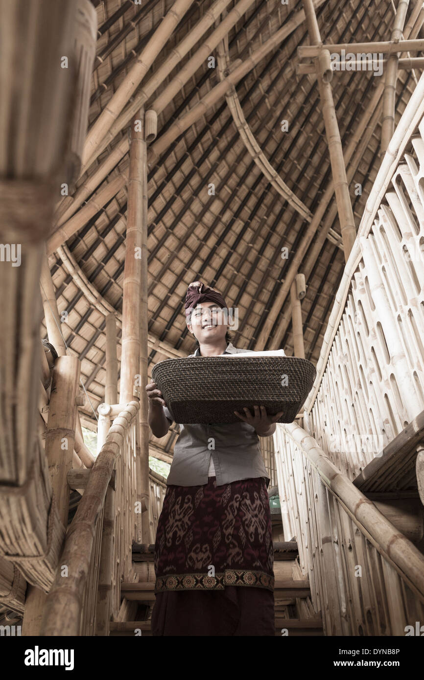 Balinesische Mann mit Korb in Hotel, Ubud, Bali, Indonesien Stockfoto