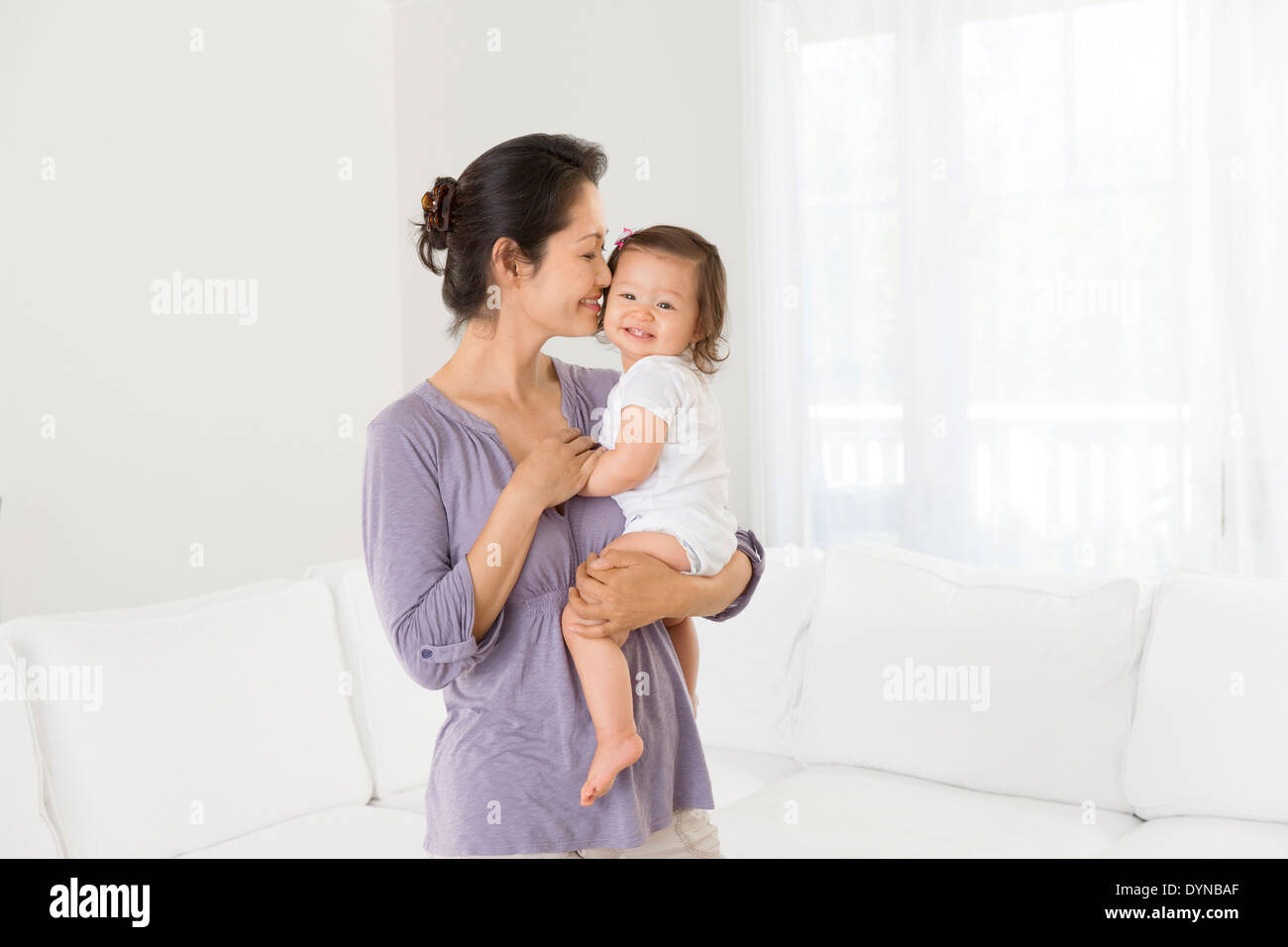 Mutter mit Babymädchen im Wohnzimmer Stockfoto