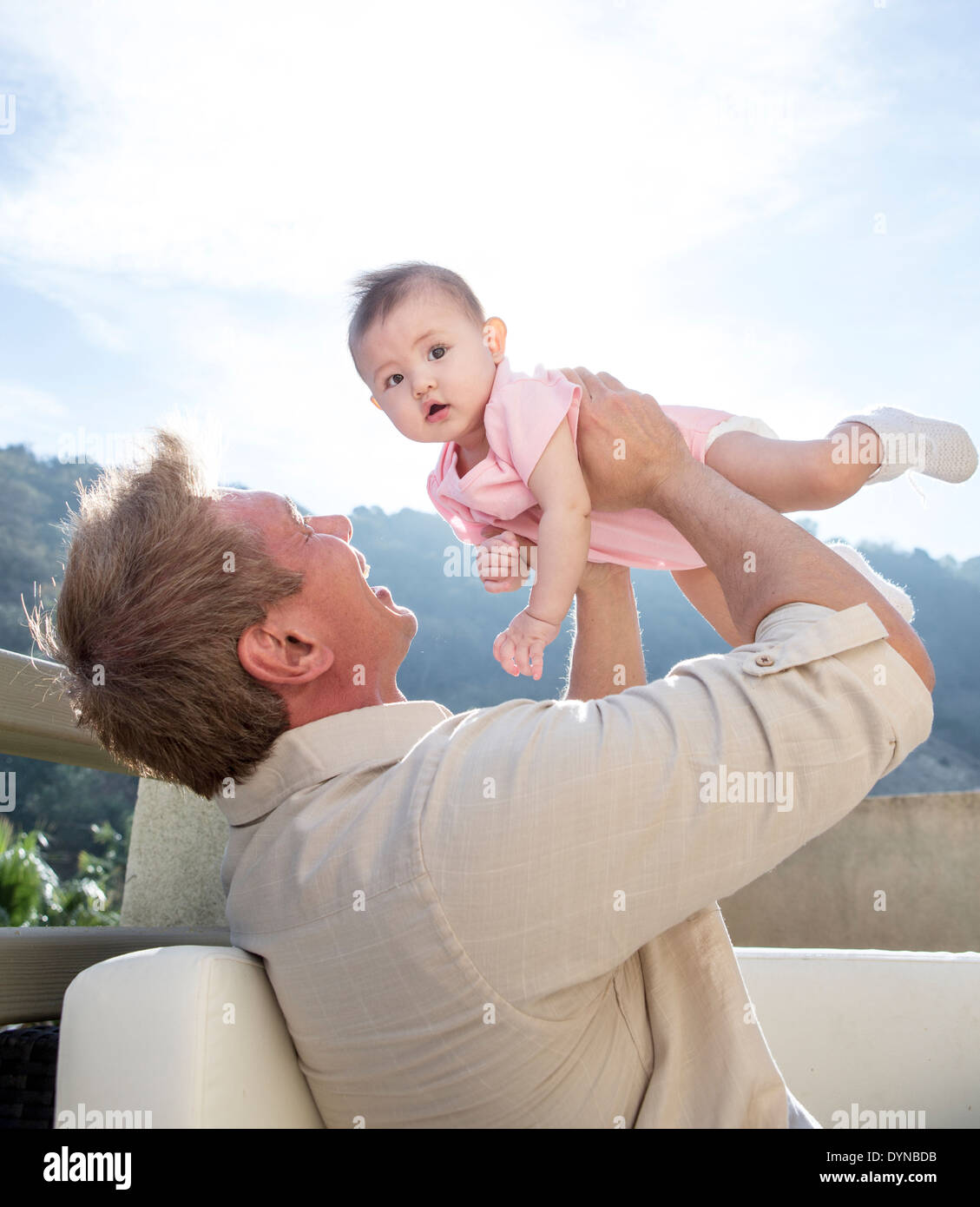 Vater hält Babymädchen auf sofa Stockfoto