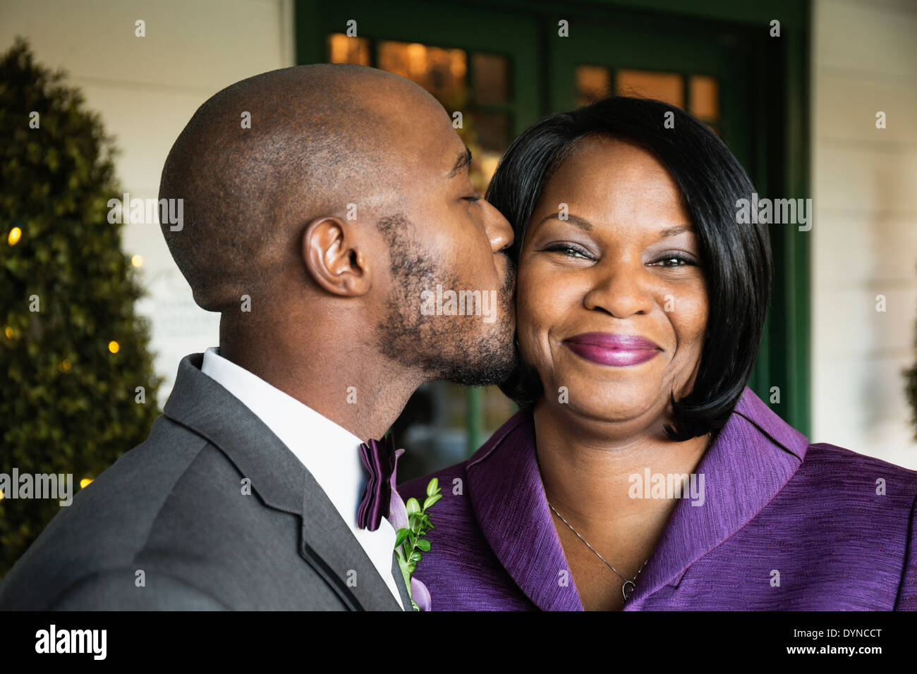Schwarze Bräutigam küssen Mutter bei Hochzeit Stockfoto