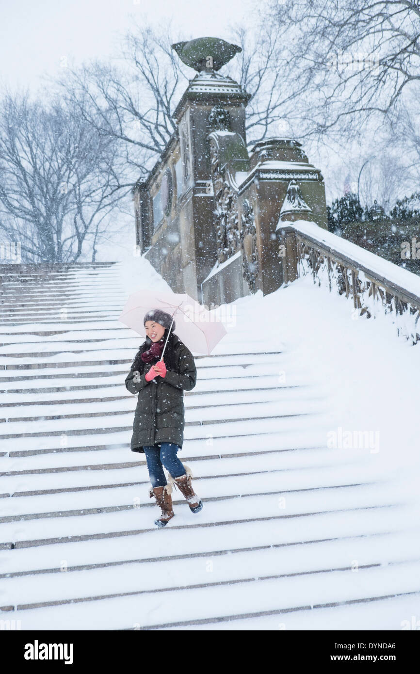 Asiatische Frau zu Fuß auf verschneiten Schritte Stockfoto