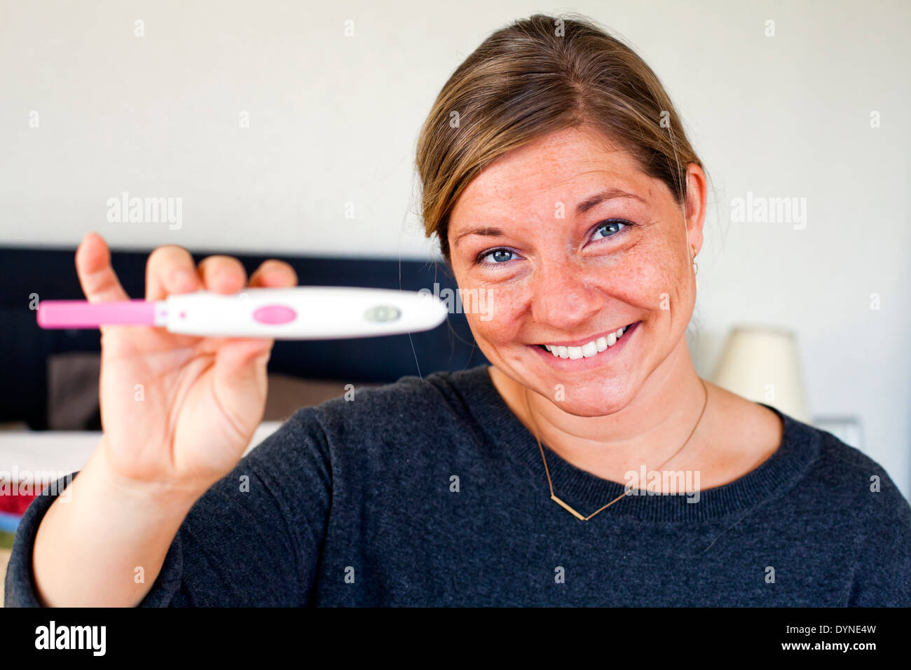 Kaukasische Frau mit positiven Schwangerschaftstest Stockfoto